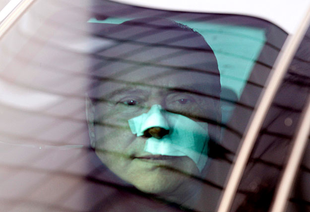 Italy's Prime Minister Silvio Berlusconi (C) leaves the San Raffaele hospital in Milan December 17, 2009. Berlusconi was discharged from hospital on Thursday, four days after an attack which left him with a fractured nose and broken teeth. REUTERS/Gi