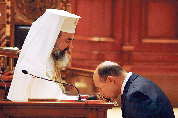 Traian Basescu megcsókolja a keresztet amelyet Daniel román ortodox pátriárka tart.