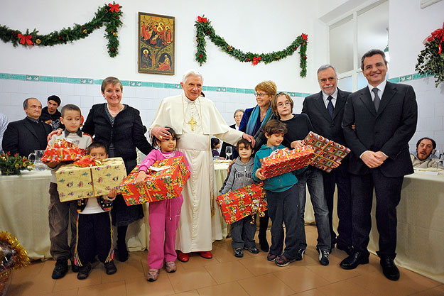 Róma, 2009. december 27.
XVI. BENEDEK pápa (fehérben) megajándékozott gyerkekkel áll a Szent Egyed (Sant'Egidio) világi katolikus közösség által fenntartott római népkonyhán 2009. december 27-én. A római katolikus egyházfő szegényekkel és hajléktala