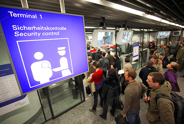 Várakozó utasok a frankfurti reptéren. 