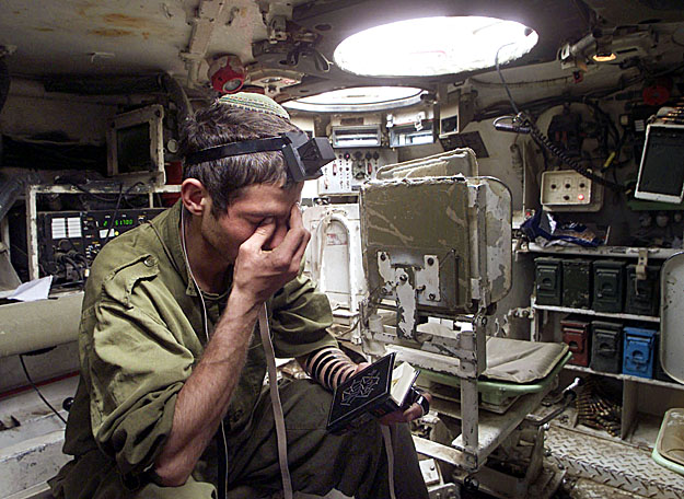 Izraeli katona imádkozik egy harci jármű belsejében
