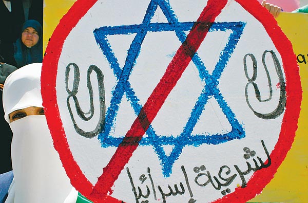 Hamaszos tüntetõ Izrael-ellenes táblával 