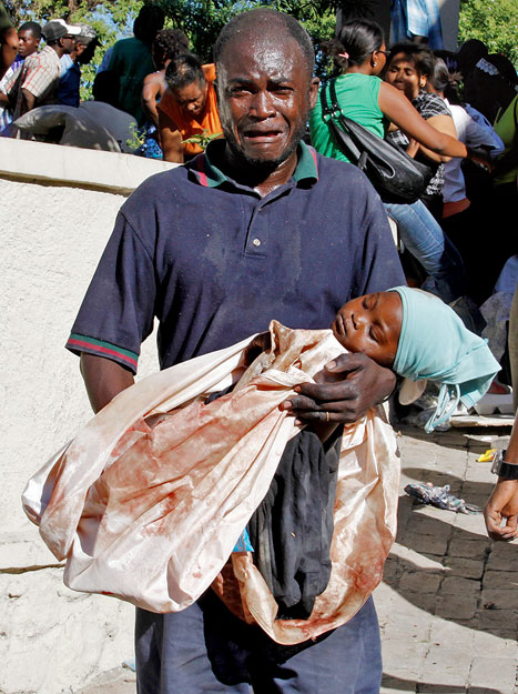 Férfi kislánya holttestével Port-au-Prince-ben