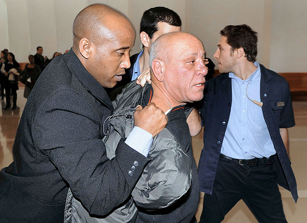 Court security guards detain a man (C) at Israel's Supreme Court building in Jerusalem January 27, 2010. Israel's chief justice Dorit Beinisch was struck in the face on Wednesday by a shoe thrown by the man, a spectator in court, witnesses to the att