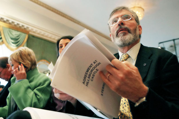 A Sinn Fein elnöke Gerry Adams a megállapodással a kezében.