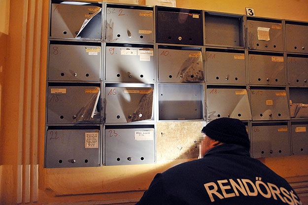 Egy rendőr helyszíneli a feltört postaládákat a főváros VIII. kerületében