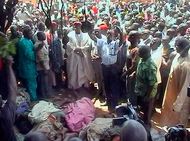A nigériai NTA TV adásából készített felvételen helybeliek gyülekeznek az út szélén kiterített áldozatok köré a nigériai Jos városától 5 km-re délre fekvő Dogo Nahawában 2010. március 7-én