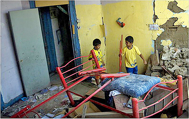Painaqueo asszony két gyermeke a megrongálódott lakásban