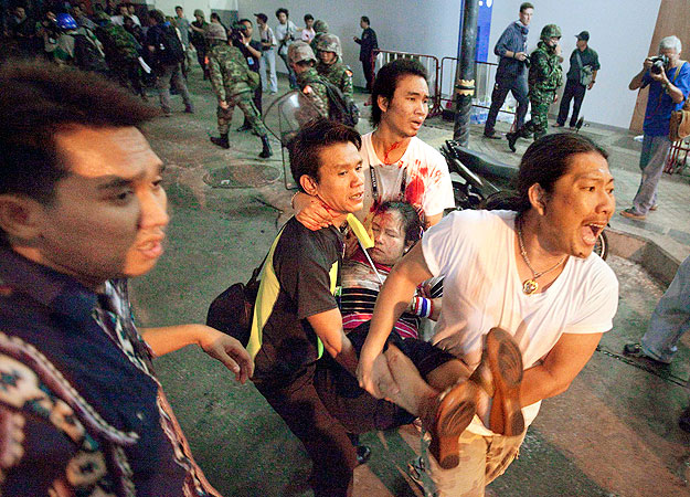 Sebesült nőt visznek Bangkokban a gránátvetős támadás után