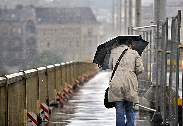 Egy gyalogos halad esernyővel a kezében a Margit-hídon, miután vihar tört ki Budapesten