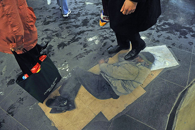 Egy hajléktalanokat ábrázoló kép a metró Deák téri aluljárójában. Az életnagyságú fotómatricák egy társadalmi célú hirdetés részei, egyben Forgács Simon, az Iparművészeti Egyetem vizuális komunikáció-videó szakos hallgatójának diplomamunkája. A proje