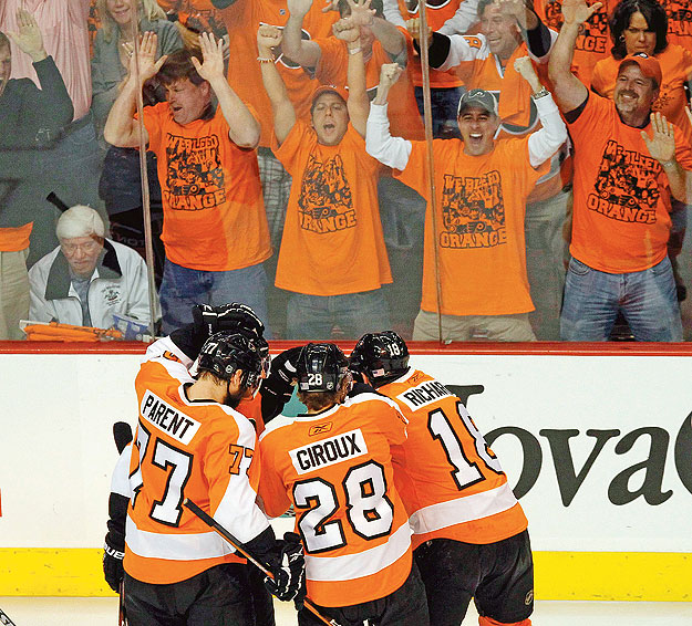 Montreal Canadiens' Glen Metropolit (L) looks on as Philadelphia Flyers' Ryan Parent (77), Claude Giroux (2nd R) and Mike Richards (R) celebrate a first period goal in Game 5 of their NHL Eastern Conference final hockey series in Philadelphia, Pennsy