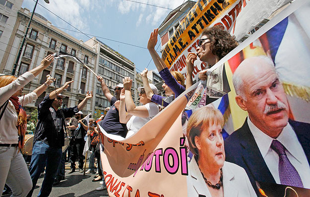 Demonstrators in Athens carry a banner featuring pictures of German Chancellor Angela Merkel and Greece's Prime Minister George Papandreou during a day of strikes in Greece, May 20, 2010. Thousands of Greeks marched on parliament today in the first m