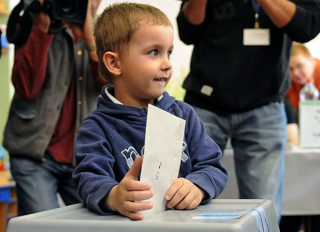 Egy cseh kisfiú adja le szülei szavazatát a 2010-es választásokon.