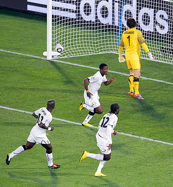 A ghánai játékosok ünneplik a győzelmet hozó tizenegyest. Középen a gólt lövő Asamoah Gyan