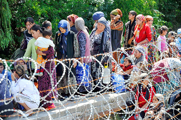 Ethnic Uzbek refugees, who fled the violence in Kyrgyzstan, wait for their turn to cross the border to Uzbekistan near the village of Jalal-Kuduk, June 14, 2010. In Uzbekistan, a tent camp has been erected while refugees are occupying schools and oth