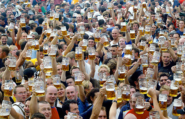 Visitors toast with their one-liter beer mugs during the opening day of the Munich Oktoberfest beer festival in Munich September 20, 2003. Thousands of beer drinkers from around the world, many in traditional Bavarian lederhosen, flocked to Munich on