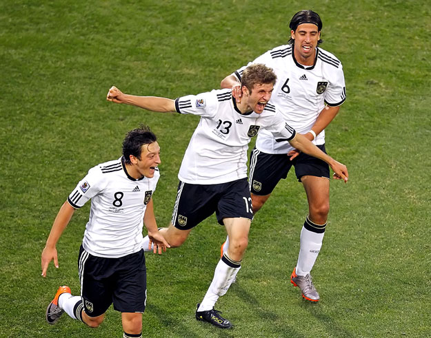 Germany's Thomas Mueller (C) celebrates scoring a goal with teammates Mesut Ozil (L) and Sami Khedira during a 2010 World Cup second round soccer match against England at Free State stadium in Bloemfontein June 27, 2010. REUTERS/Kim Kyung-Hoon (SOUTH