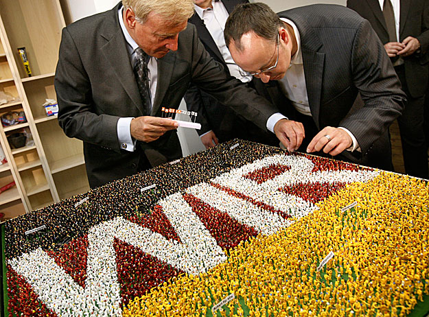 Ole von Beust hamburgi polgármester és a Miniatur Wunderland tulajdonosa, Frederik Braun Angela Merkel nevét tűzik egy  makettre 2009-ben