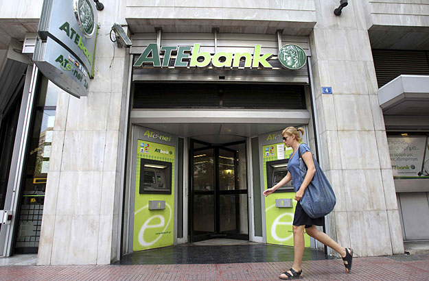 A woman walks in front of a branch of ATEbank in Athens July 23, 2010. Shares in Greek state-controlled lender ATEbank fell on Friday on concerns that it would announce it needs to raise capital after bank stress tests are published later in the day,