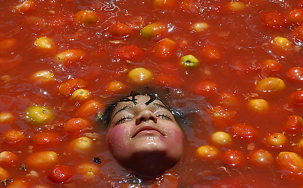 Paradicsomok közt fürdőző kis gyermek az indiai Hyderabadban