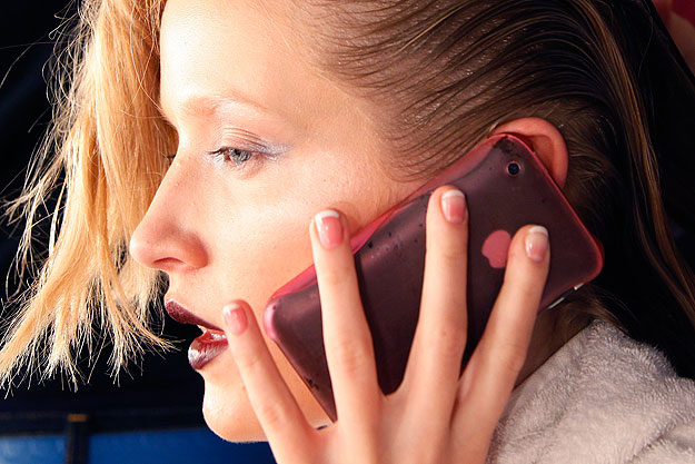 A model uses her mobile phone backstage before the presentation of Basso and Brooke 2010 Spring/Summer collection show during London Fashion Week, September 22, 2009.  