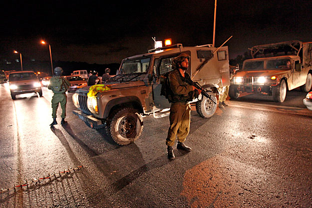 Hebron, 2010. szeptember 1.Izraeli katonák zárják le a ciszjordániai Hebron közelében lévõ Bani Naimba vezetõ utat 2010. augusztus 31-én, azt követõen, hogy a megszállt palesztin területen agyonlõttek négy izraeli telepest a Hamász szélsõséges pales
