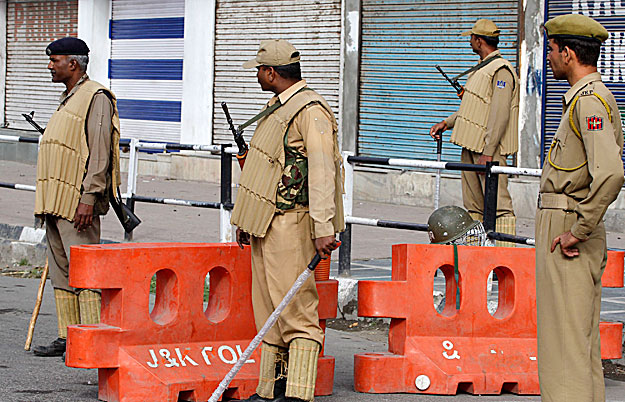 Indian policemen stand guard in front of closed shops during a curfew in Srinagar September 13, 2010. India extended a curfew on Monday across most of the part of Kashmir it controls and deployed thousands of troops to quell anti-India demonstrations