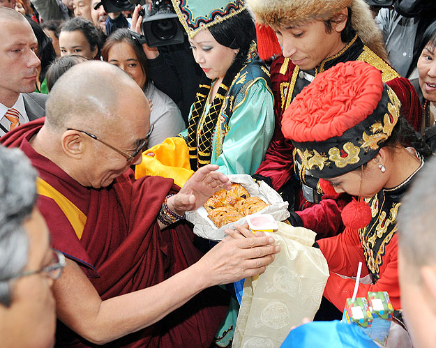 A XIV. dalai lámát süteménnyel és Sió almalével kínálják érkezésekor a Boscolo Hotel bejáratánál