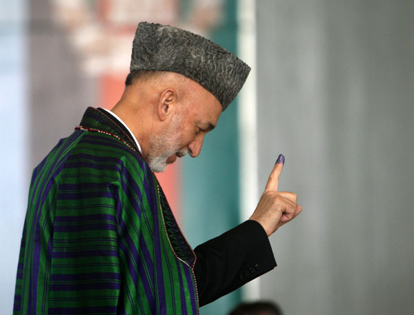 Afghan President Hamid Karzai shows a finger stained with ink before casting a vote at a school next to the presidential palace during parliamentary election in Kabul September 18, 2010. REUTERS/Andrew Biraj (AFGHANISTAN - Tags: POLITICS ELECTIONS)