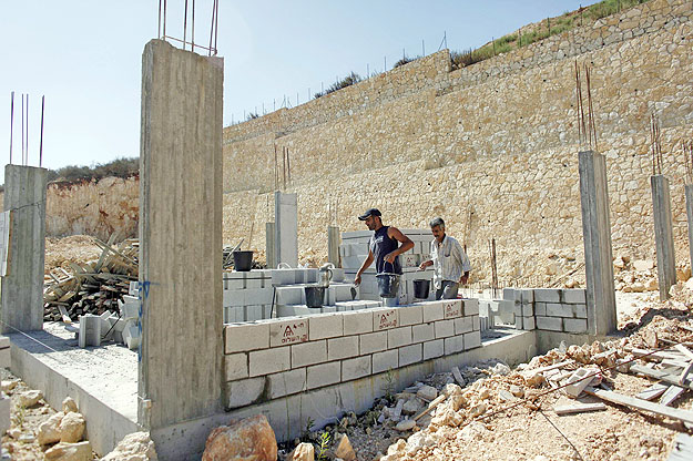 A ciszjordániai Oranit zsidó telepen palesztin munkások építenek egy új házat