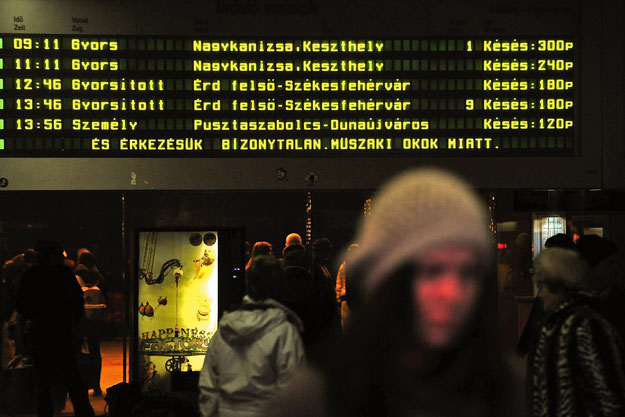 Várakozó utasok egy vasúti pályaudvaron – összehangolják a buszok és a vonatok menetrendjét
