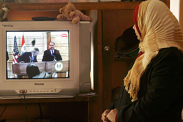 Muntaszir az-Zaidi húga videófilmet néz Bushról bagdadi lakásán 2008 december 14-én. Az iraki újságíró a megvetés jeleként egy nappal korábban hajította cipőit Bush felé egy sajtótájékoztatón