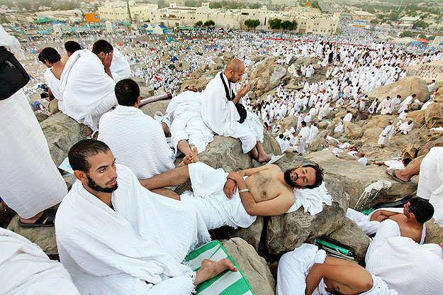 Muslim pilgrims rest as others pray on Mount Mercy on the plains of Arafat, outside the holy city of Mecca, November 15, 2010. At least 2.5 million Muslims began the annual haj pilgrimage on Sunday, heading to an encampment near the holy city of Mecc