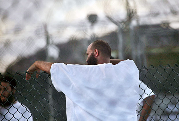 Guantánamo, 2009. máájus 21.
2009. május 13-i kép, amelyen egy őrizetes kerítésre teszi karját napkeltekor a kubai Guantánamói-öbölben lévő amerikai haditengerészeti támaszponton létesített fogolytábor udvarán. Május 21-én Barack Obama amerikai elnö
