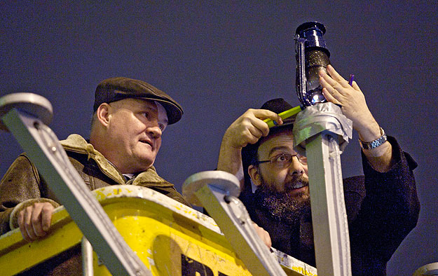 Budapest, 2010. december 1.
Hende Csaba honvédelmi miniszter (b) és Oberlander Báruch, a Chábád Lubavics Mozgalom alapítója meggyújtja a hanuka ünnepség kezdetén a hanukián Európa egyik legnagyobb menórájának első gyertyáját a budapesti Nyugati tére