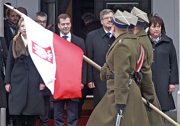 Medvegyev (balra) és vendéglátója, Komorowski a lengyel elnöki palota előtt fogadja a díszszázad tisztelgését