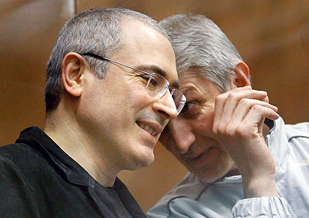 Jailed Russian former oil tycoon Mikhail Khodorkovsky (L) listens to his business partner Platon Lebedev as they stand in the defendants' cage before the start of a court session in Moscow December 28, 2010. Khodorkovsky  was found guilty of money la