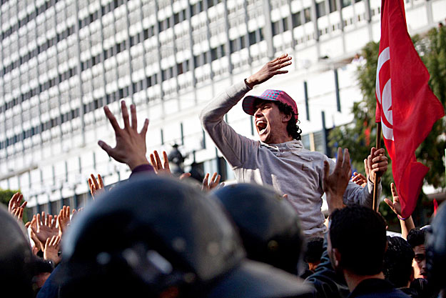 Tiltakozó tüntetők egyike jelszavakat kiáltozik Tuniszban 2011. január 19-én