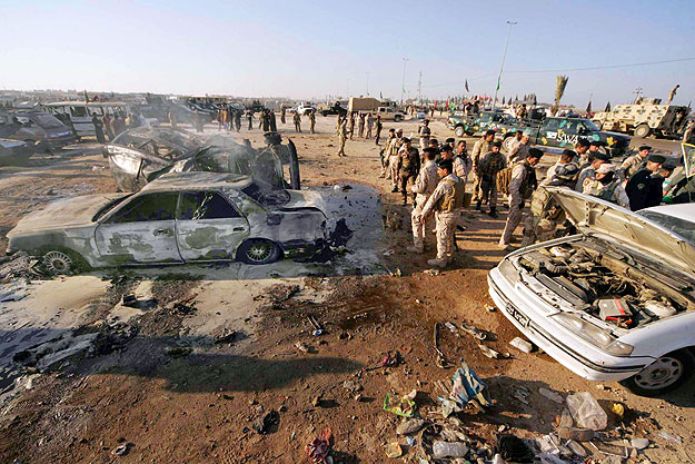 Security personnel inspect the site of a bomb attack in the holy city of Kerbala, about 80 km (50 miles) south of Baghdad, January 20, 2011. Two separate car bombs killed up to 45 pilgrims on Thursday near Iraq's holy Shi'ite city of Kerbala ahead of
