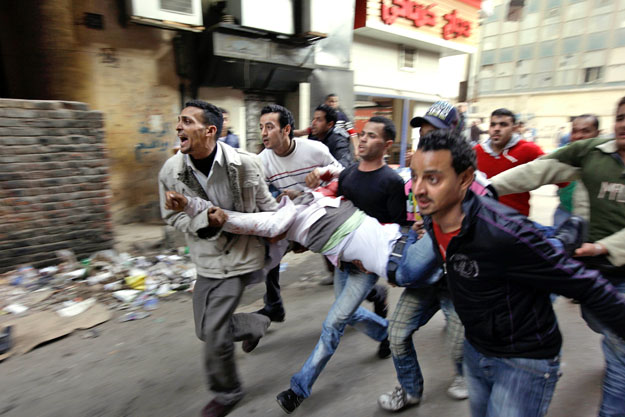 Sebesült tüntetőt visznek társai Kairóban