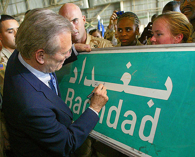 Rumsfeld – még a Pentagon irányítójaként 2003. áprilisi iraki útja során – dedikál egy bagdadi útjelző táblát