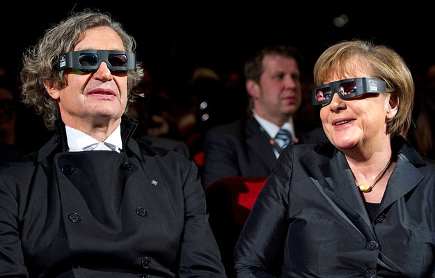 German Chancellor Angela Merkel (R) and film director Wim Wenders wear 3D glasses before the screening of the movie 'Pina' at the 61st Berlinale International Film Festival in Berlin February 13, 2011.   REUTERS/Johannes Eisele/Pool (GERMANY  - Tags: