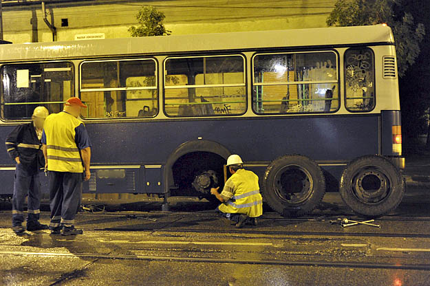 A BKV szakemberei dolgoznak a Báthory és az Ady Endre utca sarkán a 148-as BKV-busz mellett, aminek menet közben kiesett az egyik hátsó kereke