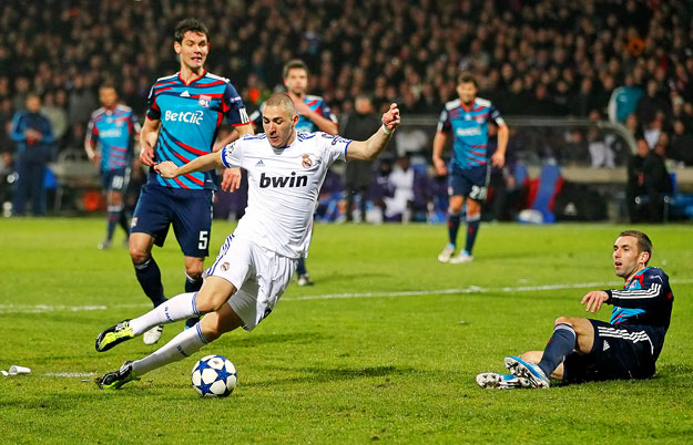 Karim Benzema (C) of Real Madrid shoots to score against Olympique Lyon during their Champions League soccer match at the Gerland stadium in Lyon February 22, 2011. 