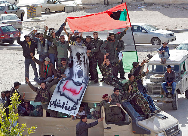 A kormányellenes tüntetők és a hozzájuk csatlakozott katonák egy katonai furgonon állva kiáltoznak Tobrukban