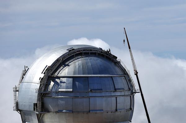 A GTC-t, vagyis a a világ legnagyobb tükrös távcsövét rejtő kupola méreteit jól mutatja a tetején dolgozó ember és a karbantartást végző öriásdaru aránya...